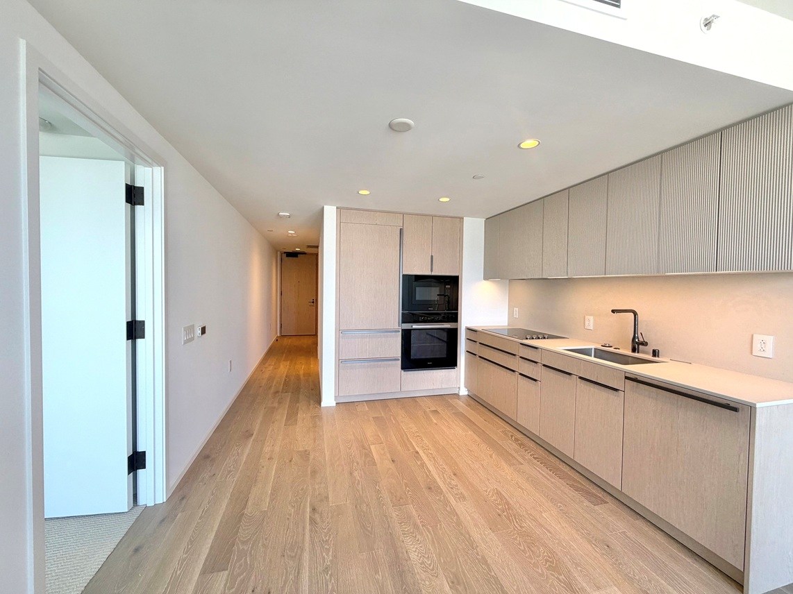 A kitchen with a sink and a refrigerator.